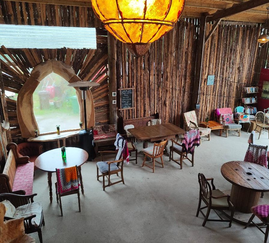 Cosy interior of a rustic tea room with wooden decor and various seating arrangements.