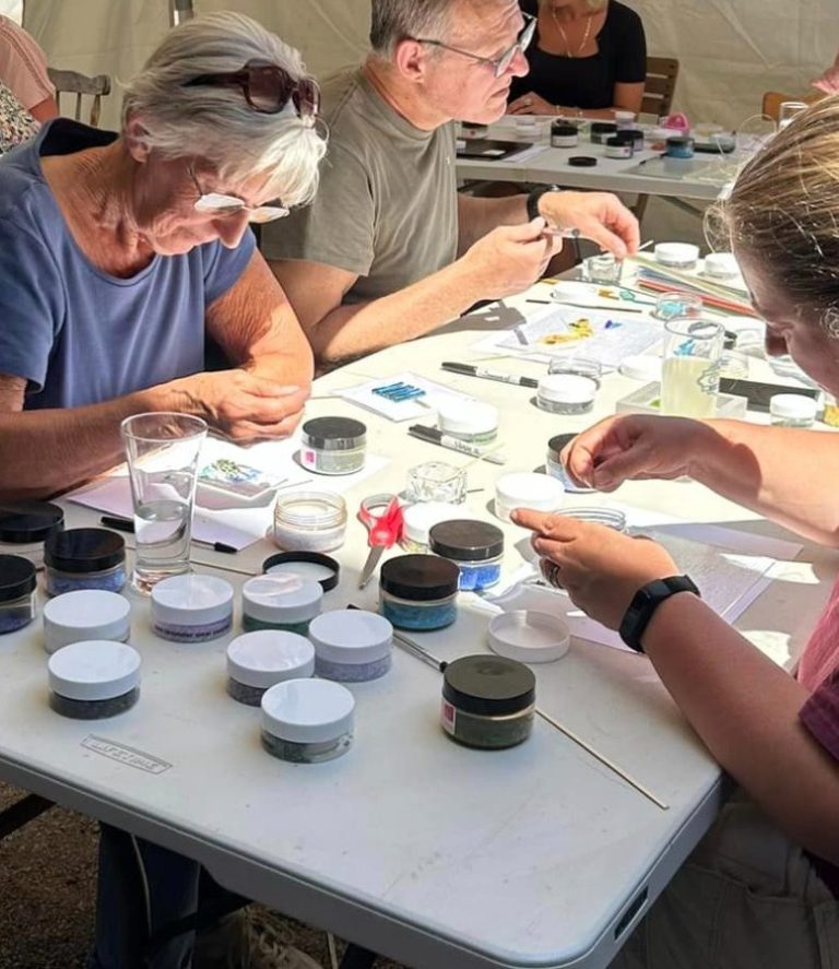 A group of people engaged in a crafting activity at a table with various materials.