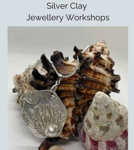 Hands working a wooden spinning wheel, guiding thread through a guide.